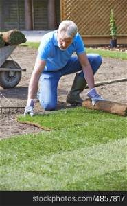 Landscape Gardener Laying Turf For New Lawn