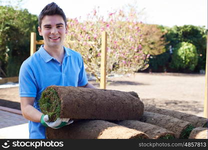 Landscape Gardener Laying Turf On New Lawn