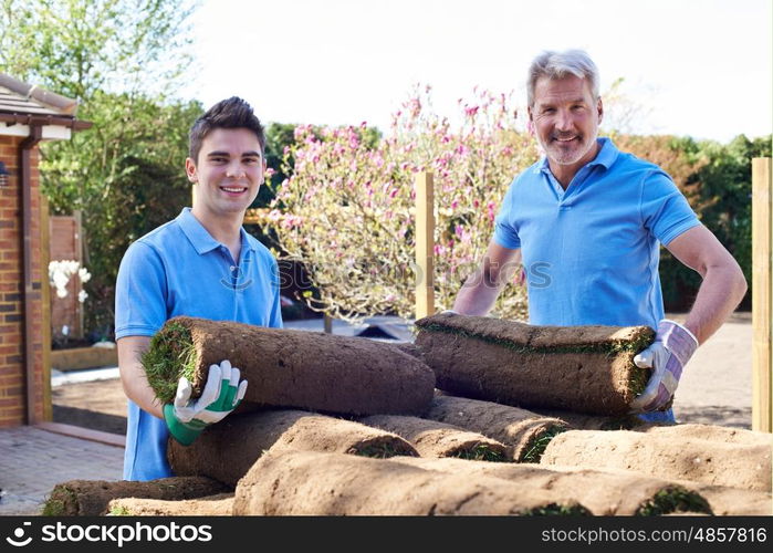 Landscape Gardeners Laying Turf For New Lawn