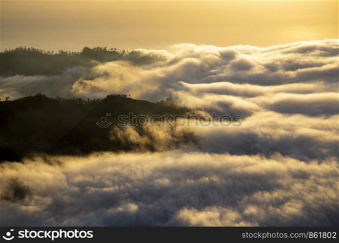 Landscape hiding in sea of ??clouds and fog at daybreak