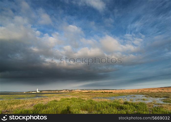 Landscape image large Summer sky with lighthouse in distance