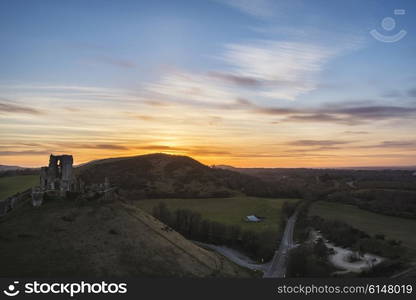 Landscape image of enchanting fairytale castle ruins during beautiful sunset