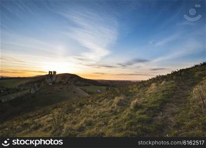 Landscape image of enchanting fairytale castle ruins during beautiful sunset