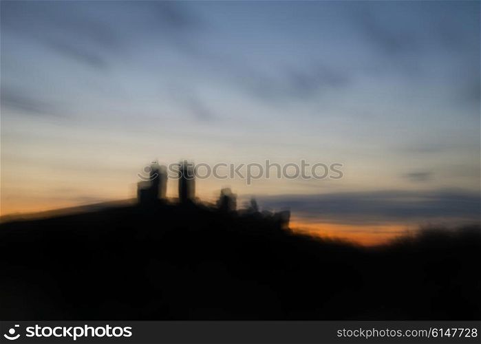 Landscape image of enchanting fairytale castle ruins during beautiful sunset with blur filter applied