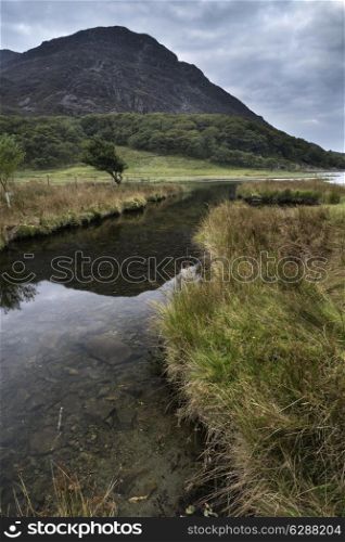 Landscape image of mountain reflected in calm lake on Summer morning