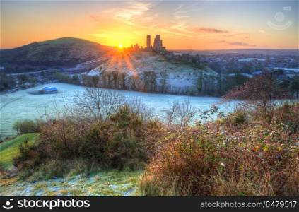 Landscape image of old Medieval castle ruins in Winter with fros. England, Dorset, Corfe Castle. Winter sunrise over Corfe Castle.. Winter sunrise landscape over old Medieval castle ruins in countryside