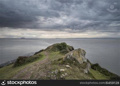 Landscape image of view out to sea with stormy sky overhead