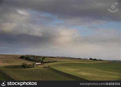 Landscape image of vineyard in English countryside scene with moody sky and clouds