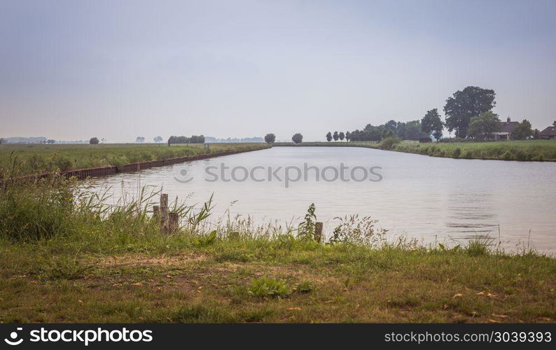 landscape in holland at the river Eem with trees at the horzion and grass in foreground. landscape with water trees and horizon. landscape with water trees and horizon