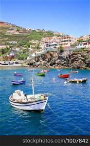 Landscape in Portugal with small fishing boats and village on mountain