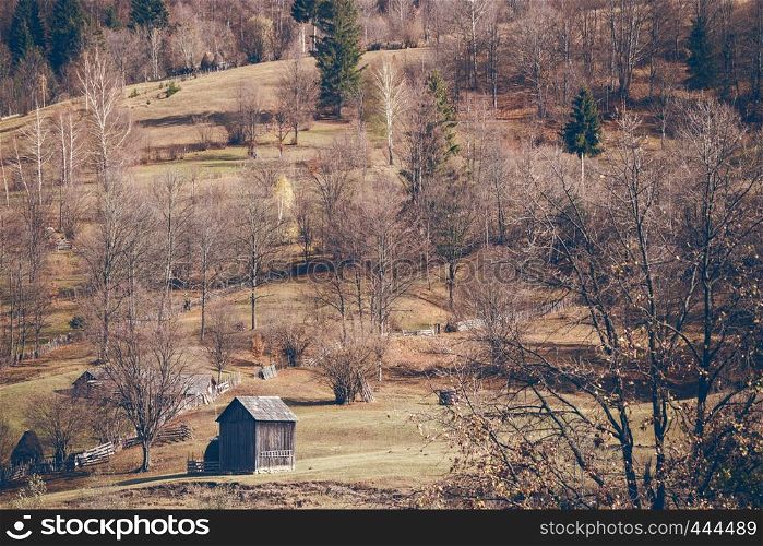 landscape in the Carpathians - view of the slope and wooden buildings, Romania