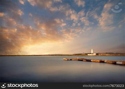 Landscape long exposure of lighthouse during Summer sunset