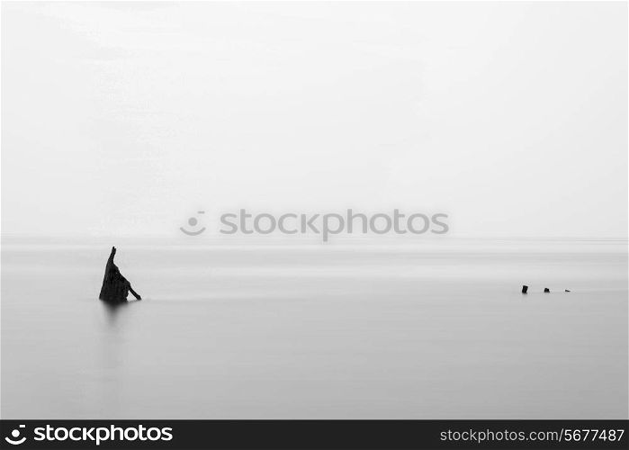 Landscape minimalist image of shipwreck ruin in sea black and white