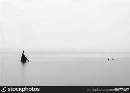 Landscape minimalist image of shipwreck ruin in sea black and white