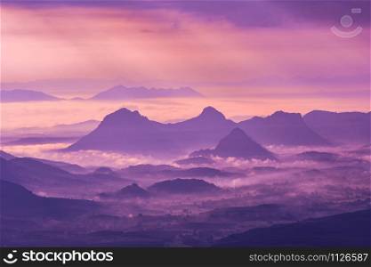 Landscape mountain with fog mist purple sky and rising sun in the morning on hill - Silhouettes mountain range background