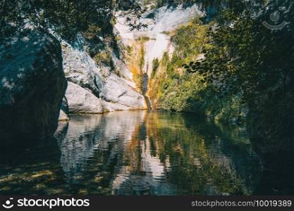 landscape of a small waterfall in a forest of tarragona, spain on a sunny day