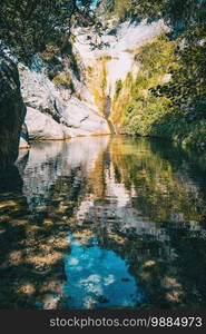 landscape of a small waterfall in a forest of tarragona, spain on a sunny day