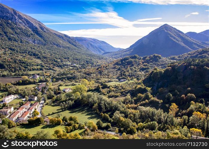 landscape of a sunny valley and mountain peaks as seen from the town of Opi, in Abruzzo national park, Italy