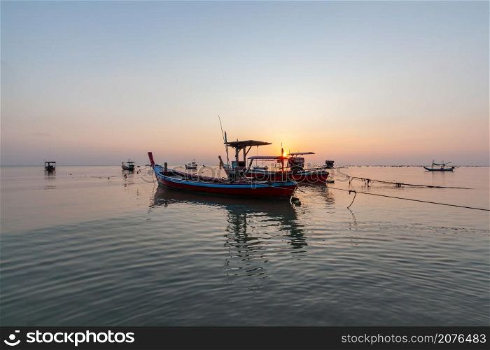 Landscape of fishing boats moored while the tide is lowers in the evening at Pakarang beach, Takuapa, Phang Nga, Thailand