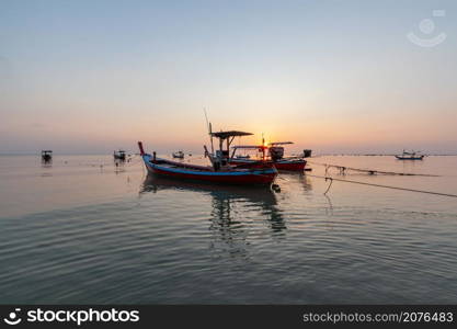 Landscape of fishing boats moored while the tide is lowers in the evening at Pakarang beach, Takuapa, Phang Nga, Thailand
