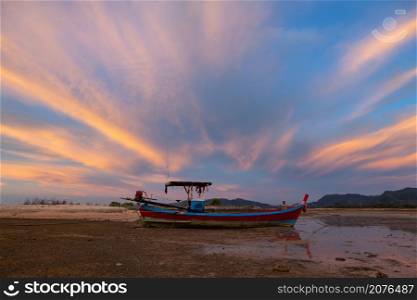 Landscape of fishing boats moored while the tide lowers in the evening at Pakarang beach, Phang Nga, Thailand