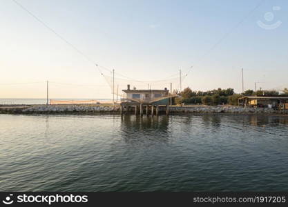 Landscape of fishing hut in the river with typical italian fishing machine, called "trabucco",Lido di Dante, fiumi uniti Ravenna near Comacchio valley.