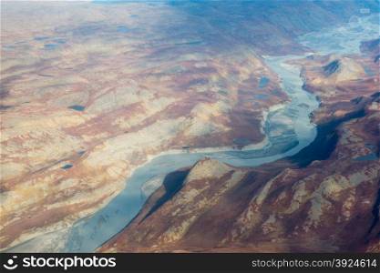 Landscape of Greenland seen from the air in summer with rocky surface, lakes and ground moraine