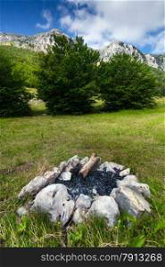 Landscape of high mountain and extinguished campfire in forest