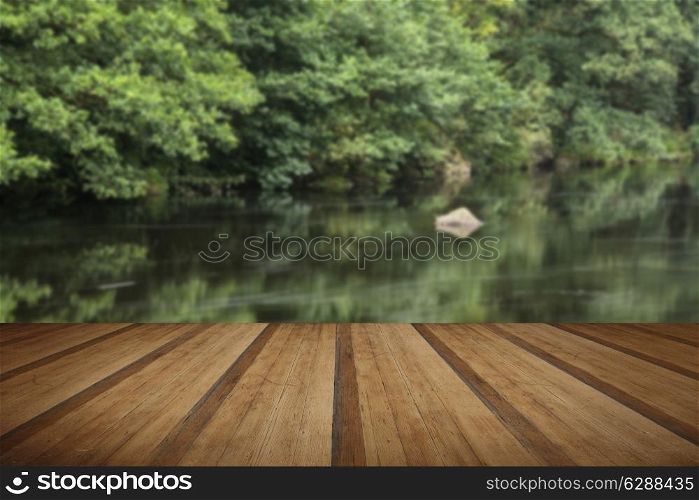 Landscape of long exposure of river flowing through lush green forest with wooden planks floor