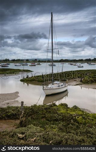 Landscape of moody evening sky over low tide marine fu of yachts