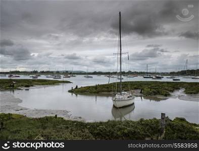 Landscape of moody evening sky over low tide marine fu of yachts