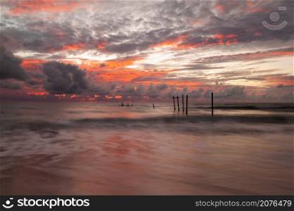 landscape of old wooden bridge with colorful sky in storm cloud at Natai, Khok Kloi, Takua Thung District, Phang-nga, Thailand.