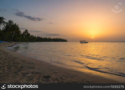 Landscape of paradise tropical island beach with boat background, sunset shot at Dominican republic ,Grand Bahia principe beach.