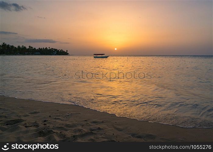 Landscape of paradise tropical island beach with boat background, sunset shot at Dominican republic ,Grand Bahia principe beach.