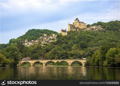 landscape of river dordogne with a bridge and the castle of castelnaid on the cliff