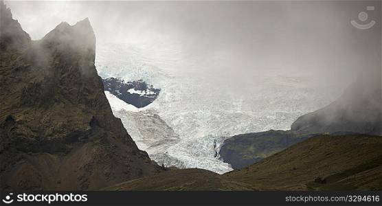 Landscape of Skaftafellsjokull glacier, framed by rugged misty mountains