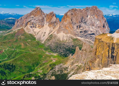 Landscape of the Langkofel Group mountain of the Dolomites at Sass Pordoi with the mountain road and the green field, South Tyrol, Italy