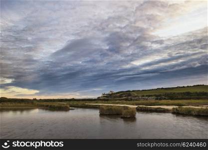 Landscape of tidal pool at coast during evening with dramatic sky