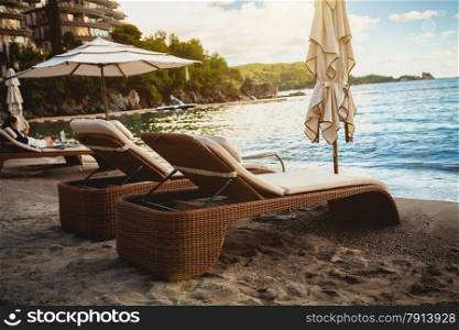 Landscape of two wooden loungers on sea beach at early morning