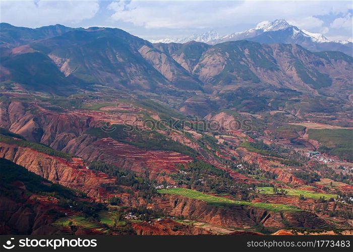 Landscape of wheat terraces and the loss of nutrient rich topsoil, snow mountain range in the backgrounds, rural scene in Yunnan, South China. Selective focus.
