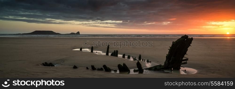 Landscape panorama shipwreck on Rhosilli Bay beach in Wales at sunset