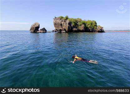 landscape photo, woman is snorkeling in tropical sea of Thailand