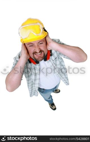 Landscape picture of worker covering his ears