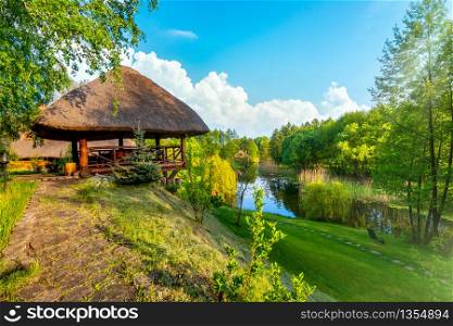 Landscape pond and forest in spring afternoon. House in spring