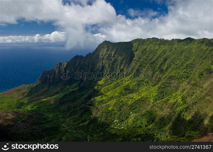 Landscape shot of the Na Pali Coast in Kauai, Hawaii on a partly cloudy day.