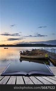 Landscape sunrise over still lake with boats on jetty conceptual book image