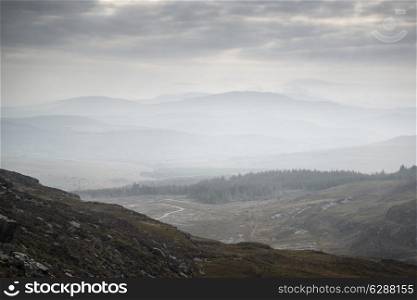 Landscape view from top of mountain on misty morning across countryside