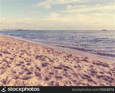 Landscape. View of blue cloudy sky at sea or ocean water with footprints at sandy beach. Resort.. Cloudy sky at sea and sandy beach.