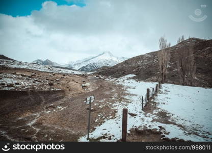 Landscape view of rural area, covered by snow and surrounded by snow capped mountains in the High Atlas range. Morocco.