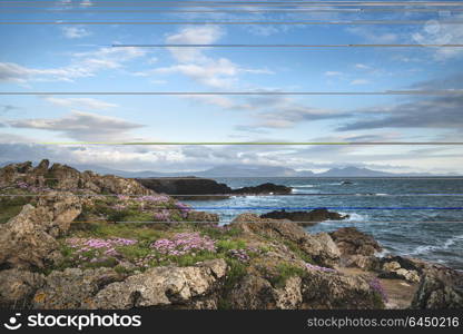 Landscape view of Snowdonia mountain range from Ynys Llanddwyn Island in Angelsey at sunset